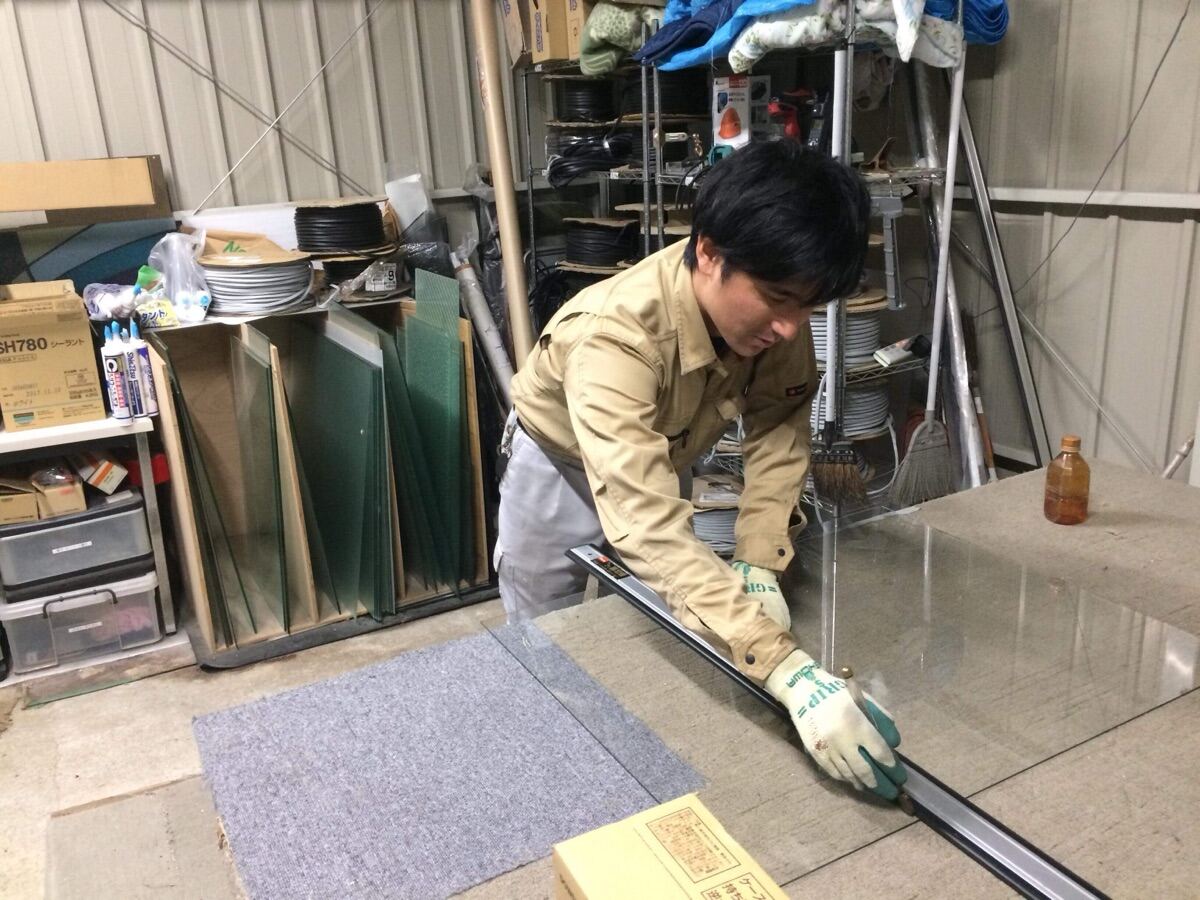 自社倉庫でガラスをカットする職人